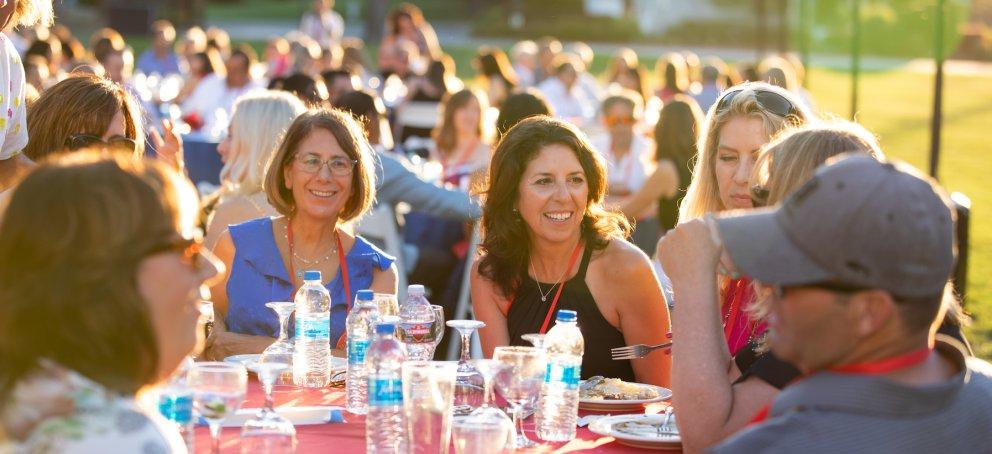 A woman smiles during twilight at Reunion Dinner